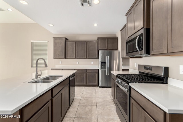 kitchen with light tile patterned flooring, appliances with stainless steel finishes, dark brown cabinetry, and sink