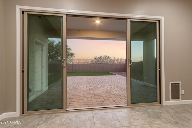 doorway to outside with light tile patterned floors