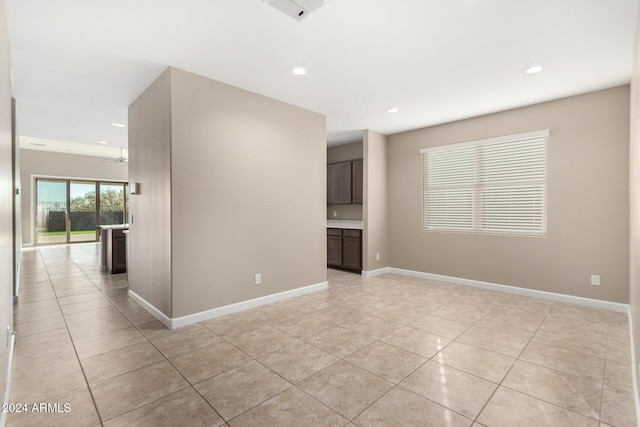 tiled empty room featuring ceiling fan