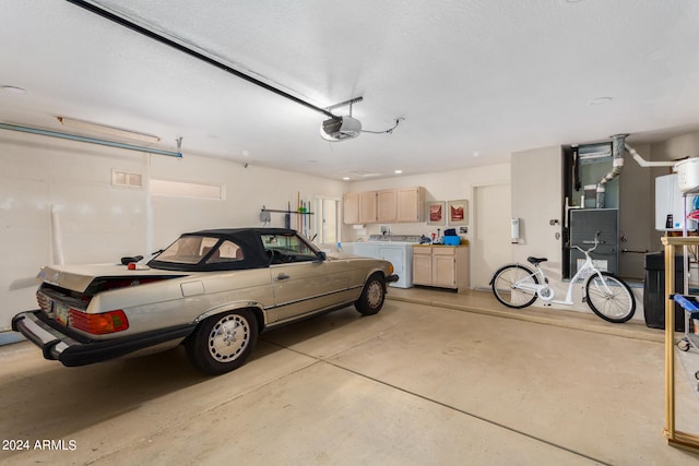 garage featuring a garage door opener, washing machine and dryer, and heating unit