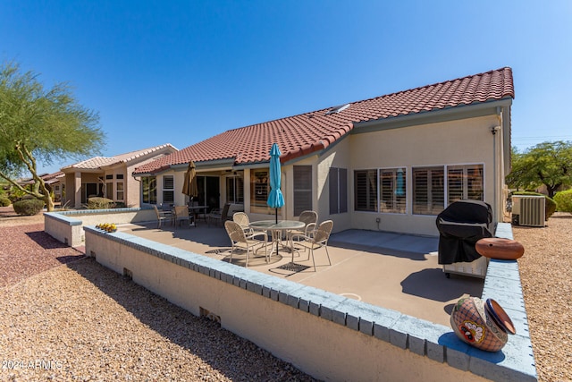 rear view of property featuring cooling unit and a patio area