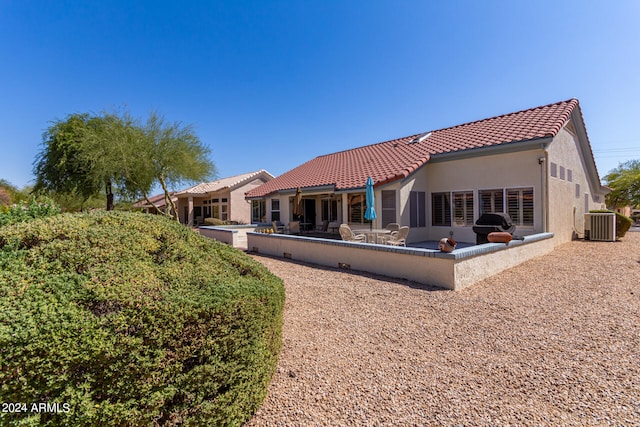 rear view of property featuring central AC unit and a patio area