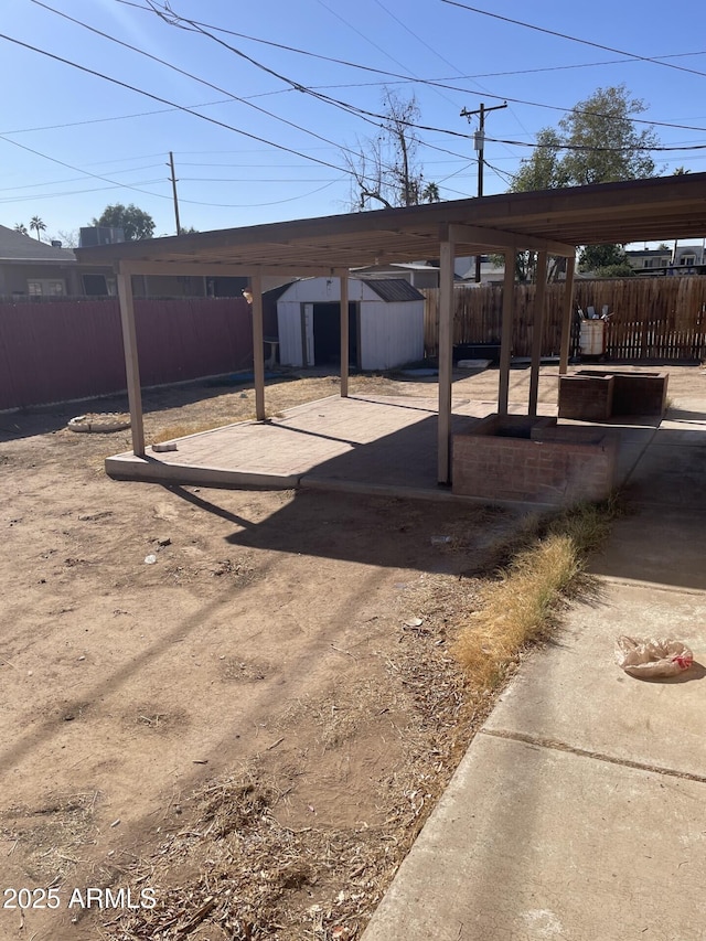 view of car parking featuring a storage unit and a fenced backyard