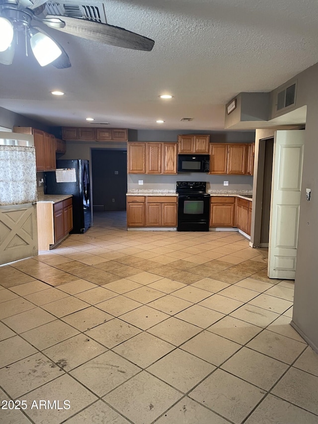 kitchen featuring black appliances, brown cabinetry, light countertops, and visible vents