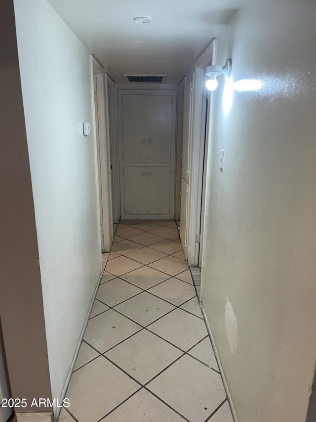 hall featuring light tile patterned floors and visible vents