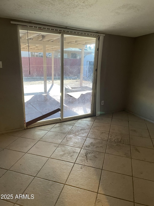 doorway to outside featuring a textured ceiling and plenty of natural light