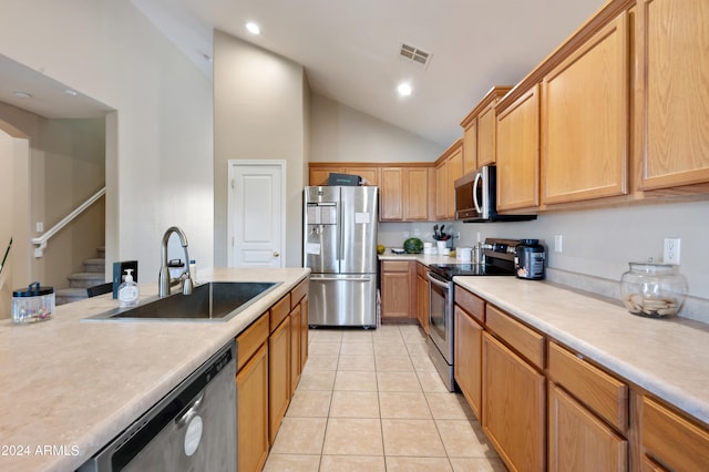 kitchen with high vaulted ceiling, appliances with stainless steel finishes, sink, and light tile patterned floors