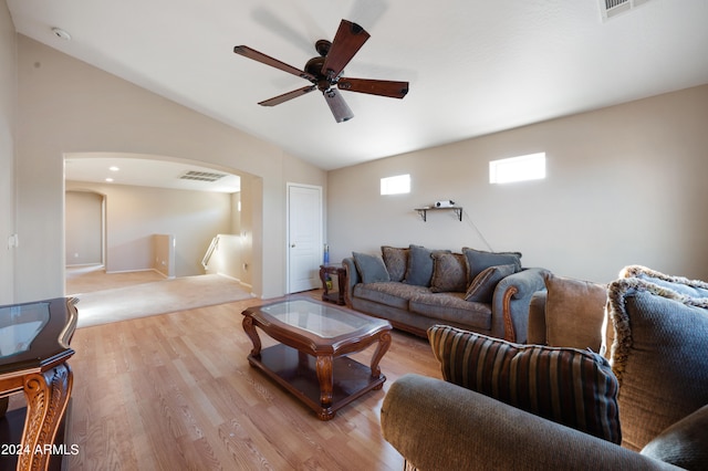 living room featuring light wood-type flooring, ceiling fan, and vaulted ceiling