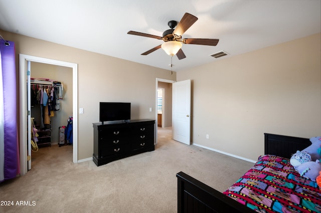 carpeted bedroom featuring ceiling fan, a closet, and a spacious closet