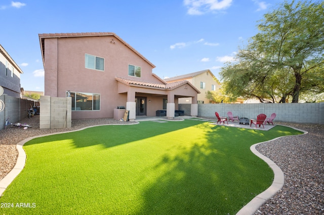 back of property with a lawn and a patio area