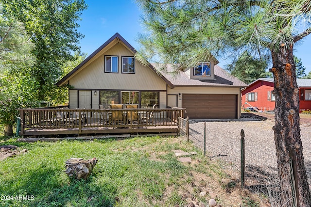 view of front of home featuring a garage, a deck, and a front lawn