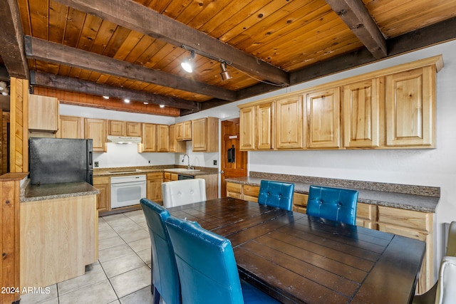 kitchen with white appliances, light brown cabinetry, and beam ceiling