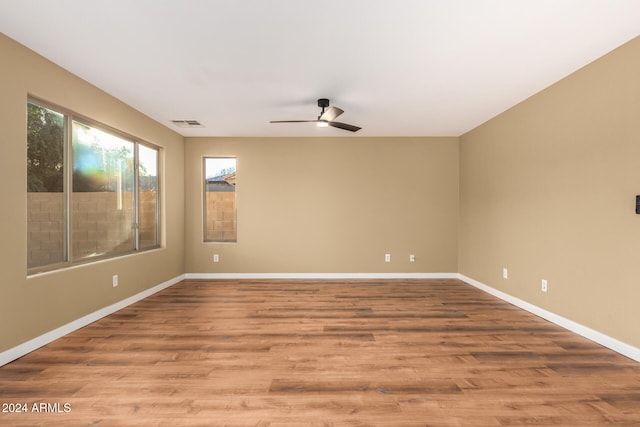 unfurnished room featuring light hardwood / wood-style floors, ceiling fan, and a healthy amount of sunlight