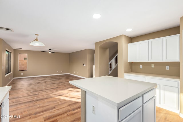 kitchen featuring a center island, light hardwood / wood-style flooring, white cabinetry, and ceiling fan