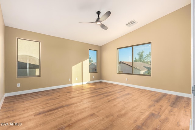 spare room featuring ceiling fan, lofted ceiling, and light hardwood / wood-style flooring