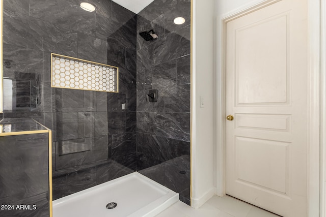 bathroom with tile patterned flooring and a tile shower