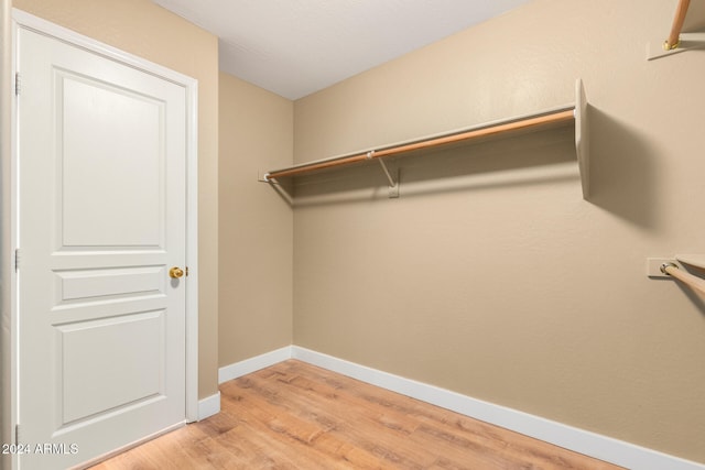 walk in closet with light hardwood / wood-style flooring