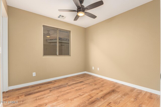 spare room with ceiling fan and light wood-type flooring