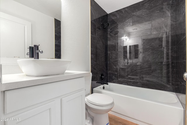 full bathroom with vanity, wood-type flooring, tiled shower / bath combo, and toilet