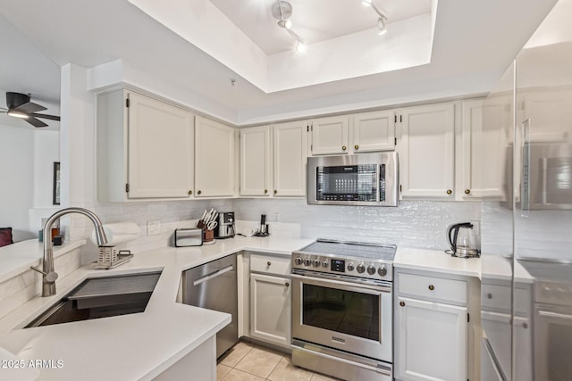 9450 E Becker Ln Unit 1046, Scottsdale, AZ 85260 - kitchen featuring appliances with stainless steel finishes, a sink, light countertops, decorative backsplash, and light tile patterned floors