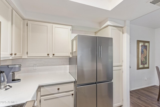 9450 E Becker Ln Unit 1046, Scottsdale, AZ 85260 - kitchen with freestanding refrigerator, white cabinets, tasteful backsplash, dark wood-style floors, and baseboards