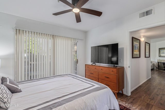 9450 E Becker Ln Unit 1046, Scottsdale, AZ 85260 - bedroom featuring dark wood-type flooring, baseboards, a ceiling fan, and access to exterior