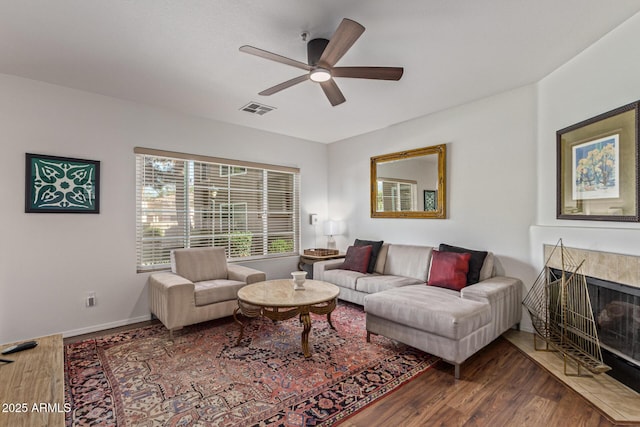9450 E Becker Ln Unit 1046, Scottsdale, AZ 85260 - living room with wood finished floors, ceiling fan, a premium fireplace, and baseboards