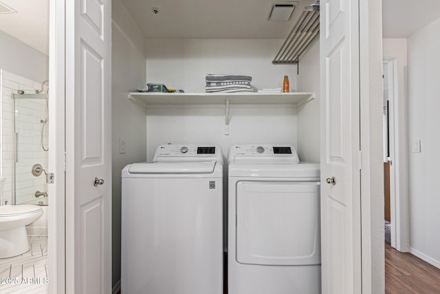 9450 E Becker Ln Unit 1046, Scottsdale, AZ 85260 - laundry room with washing machine and dryer, wood finished floors, and baseboards