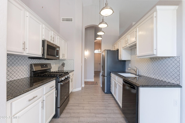3055 N Red Mtn Unit 122, Mesa, AZ 85207 - kitchen featuring appliances with stainless steel finishes, a sink, light wood-type flooring, white cabinetry, and tasteful backsplash