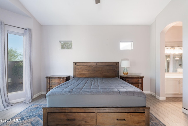 3055 N Red Mtn Unit 122, Mesa, AZ 85207 - bedroom with arched walkways, light wood finished floors, baseboards, and ensuite bathroom
