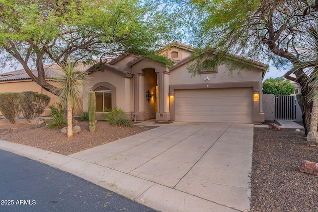 3055 N Red Mtn Unit 122, Mesa, AZ 85207 - mediterranean / spanish-style house with stucco siding, concrete driveway, an attached garage, and a gate