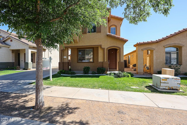 mediterranean / spanish house with stucco siding and a front lawn