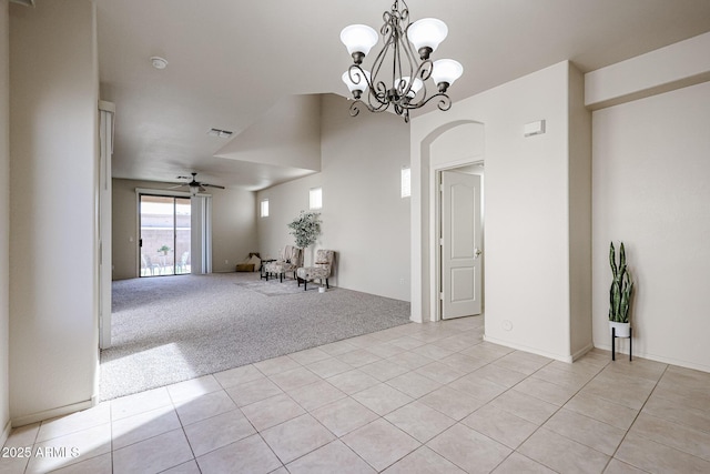 unfurnished room with ceiling fan with notable chandelier, visible vents, light carpet, and light tile patterned floors