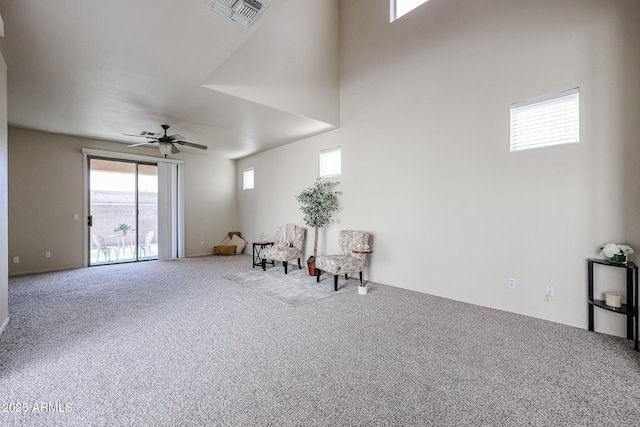 living area with carpet, visible vents, a ceiling fan, and baseboards