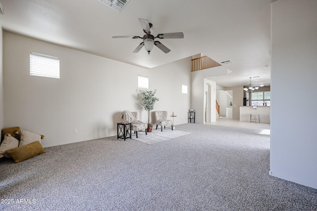 living area with carpet floors, visible vents, and ceiling fan with notable chandelier