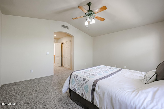 carpeted bedroom with vaulted ceiling, visible vents, arched walkways, a closet, and baseboards
