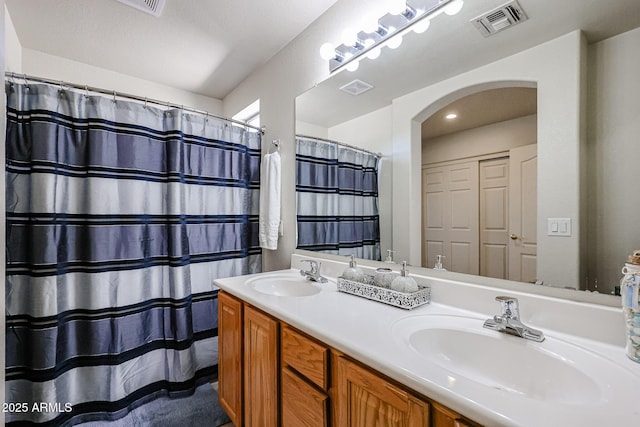 bathroom with a sink, visible vents, and double vanity