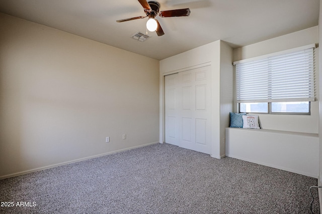 unfurnished bedroom with baseboards, visible vents, carpet, a ceiling fan, and a closet