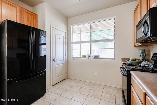 kitchen featuring tasteful backsplash, light tile patterned flooring, baseboards, light countertops, and black appliances