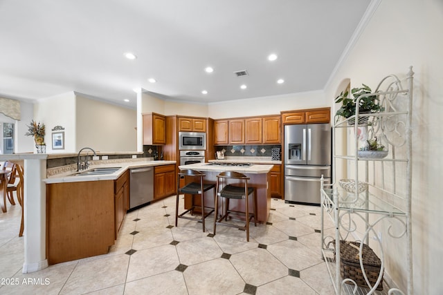 kitchen with a breakfast bar, sink, a center island, appliances with stainless steel finishes, and kitchen peninsula