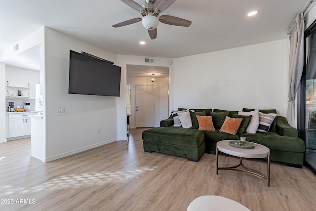 living room with ceiling fan and light hardwood / wood-style flooring