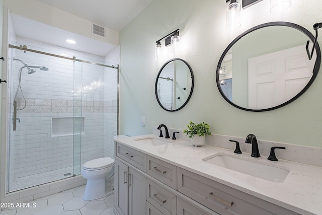 bathroom with tile patterned floors, vanity, toilet, and a shower with shower door