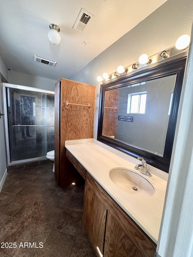 bathroom with toilet, vanity, and visible vents