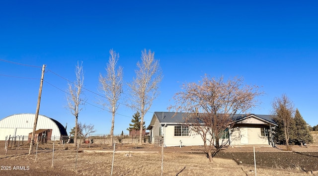 view of front of home with an outbuilding, fence, and an outdoor structure