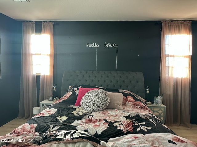 bedroom featuring multiple windows and hardwood / wood-style floors