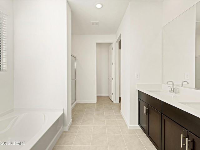 bathroom with tile patterned flooring, plus walk in shower, and vanity