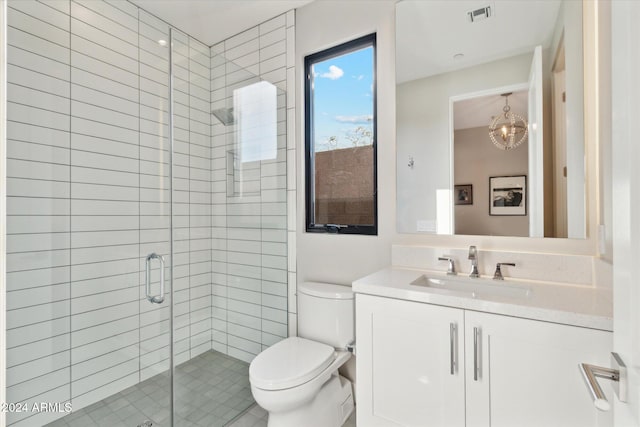 bathroom with vanity, toilet, a shower with shower door, and a chandelier