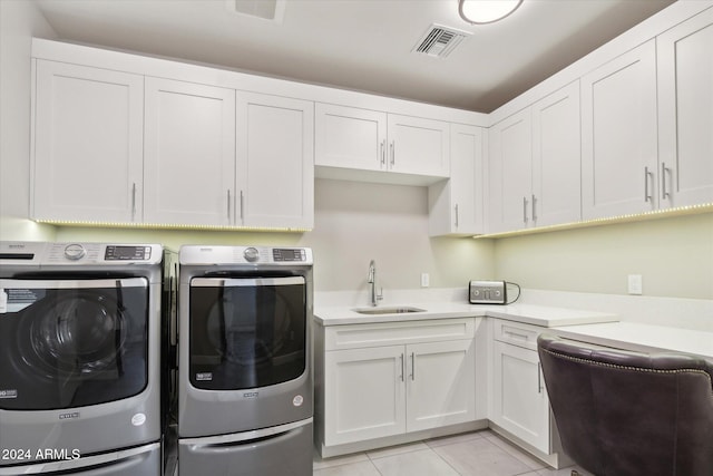 laundry area featuring cabinets, sink, washer and clothes dryer, and light tile patterned floors