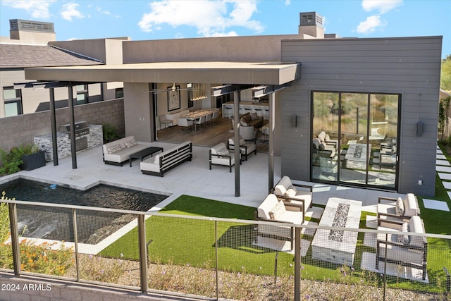 rear view of house featuring a patio area, an outdoor living space, and a yard