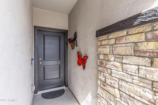 entrance to property featuring stucco siding